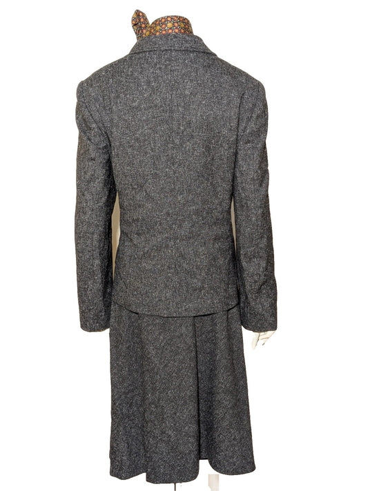 Anisette grey skirt suit with three-button blazer and knee-length skirt, tweed texture.