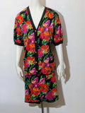 Leda Grotte black floral skirt suit with gold buttons and short balloon sleeves.