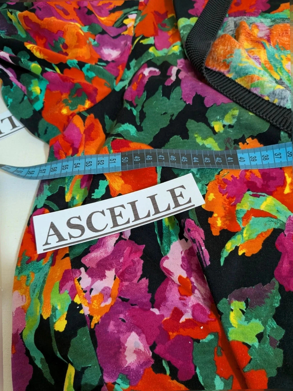 Leda Grotte black floral skirt suit with gold buttons and short balloon sleeves.