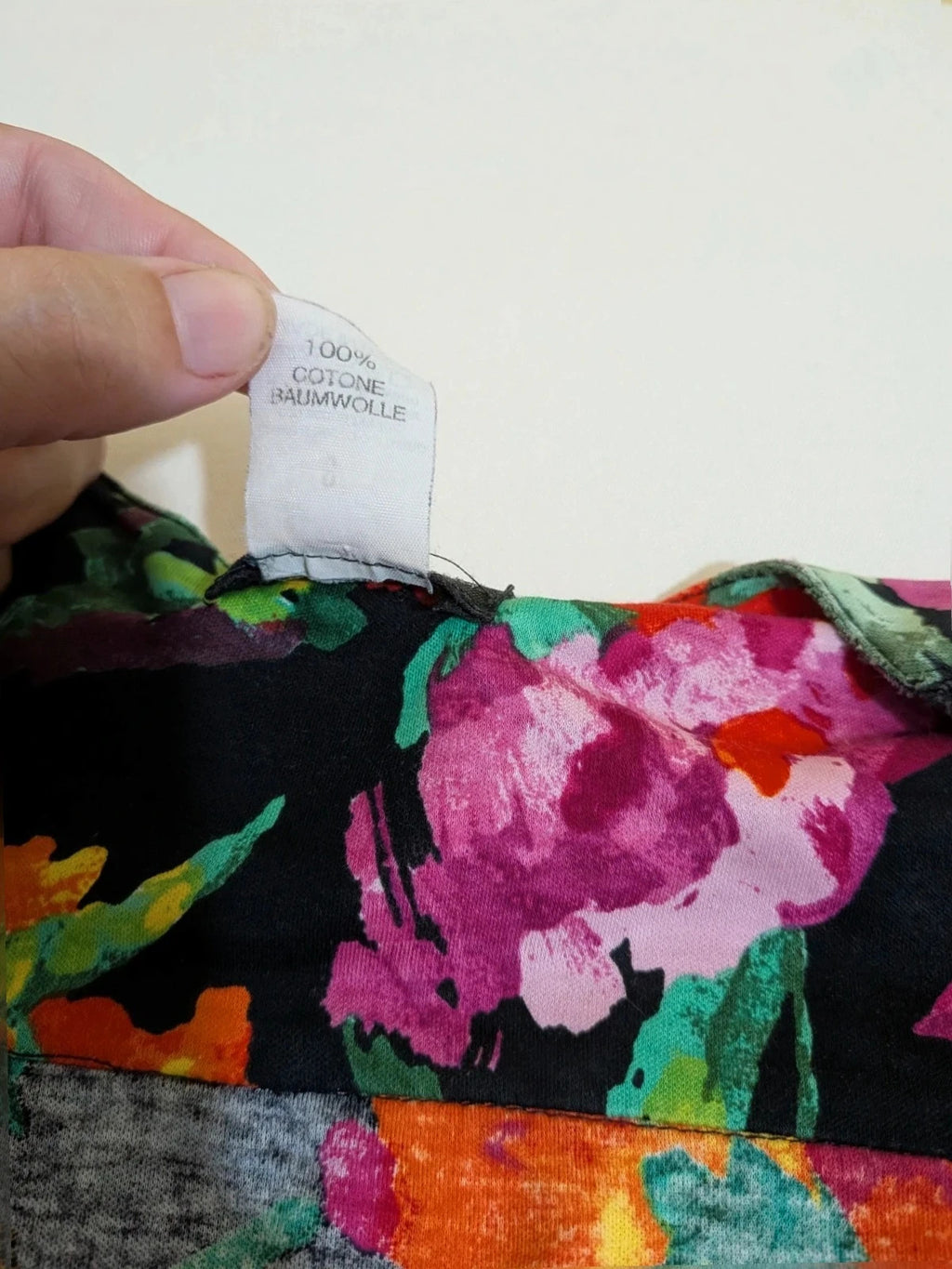 Leda Grotte black floral skirt suit with gold buttons and short balloon sleeves.