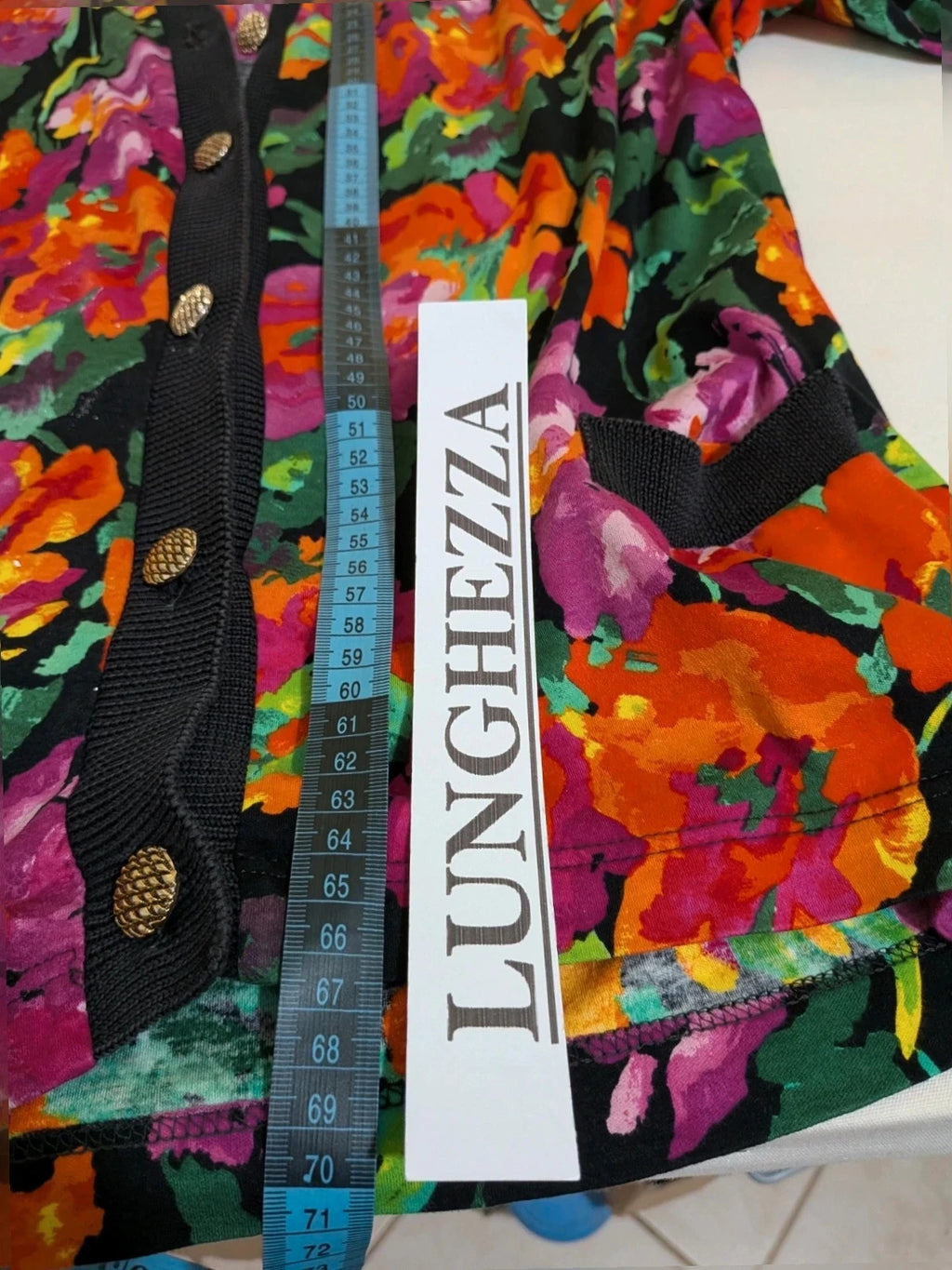 Leda Grotte black floral skirt suit with gold buttons and short balloon sleeves.