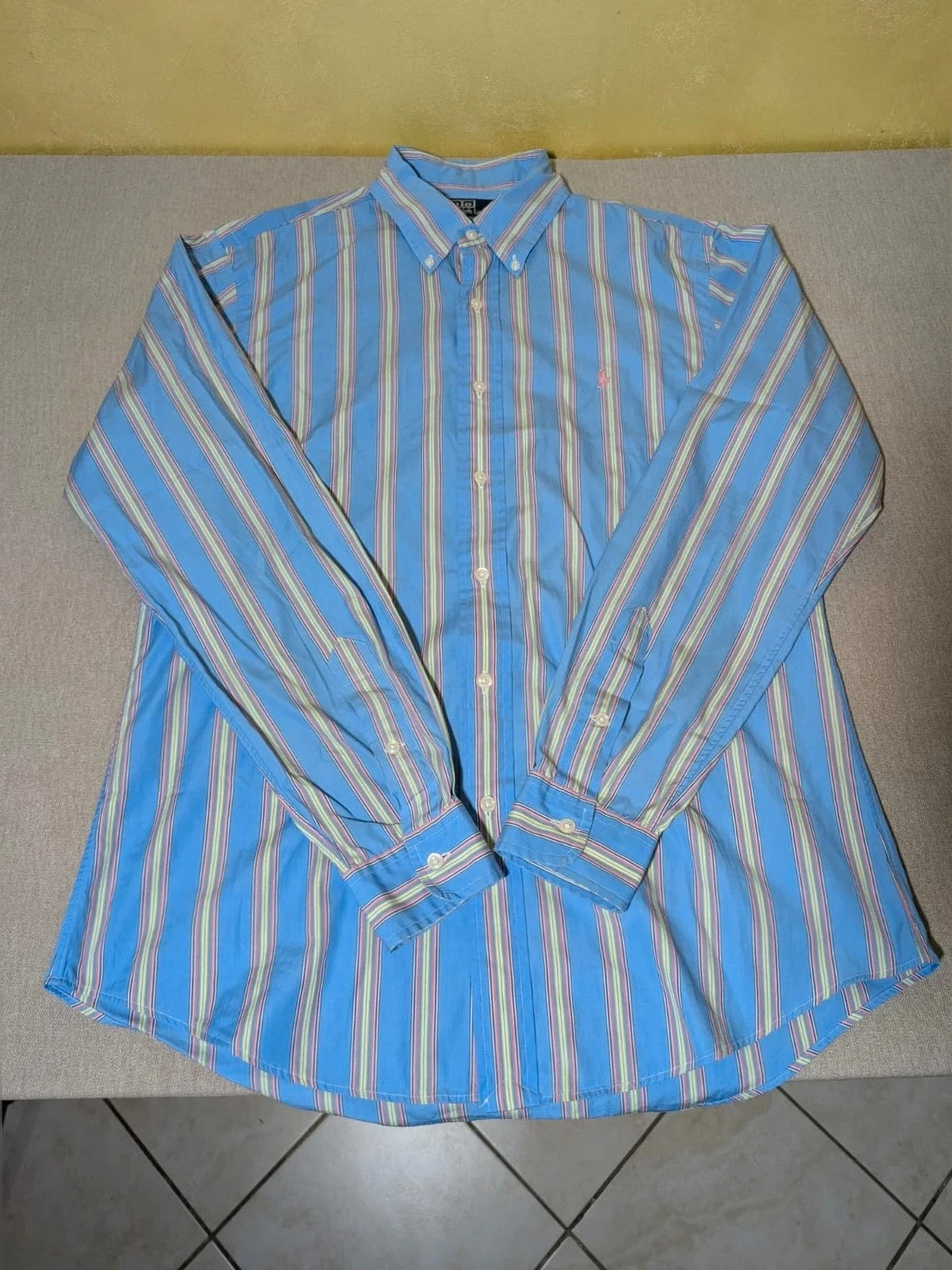 Polo Ralph Lauren multicolor striped shirt with pink pony logo on sky blue background.