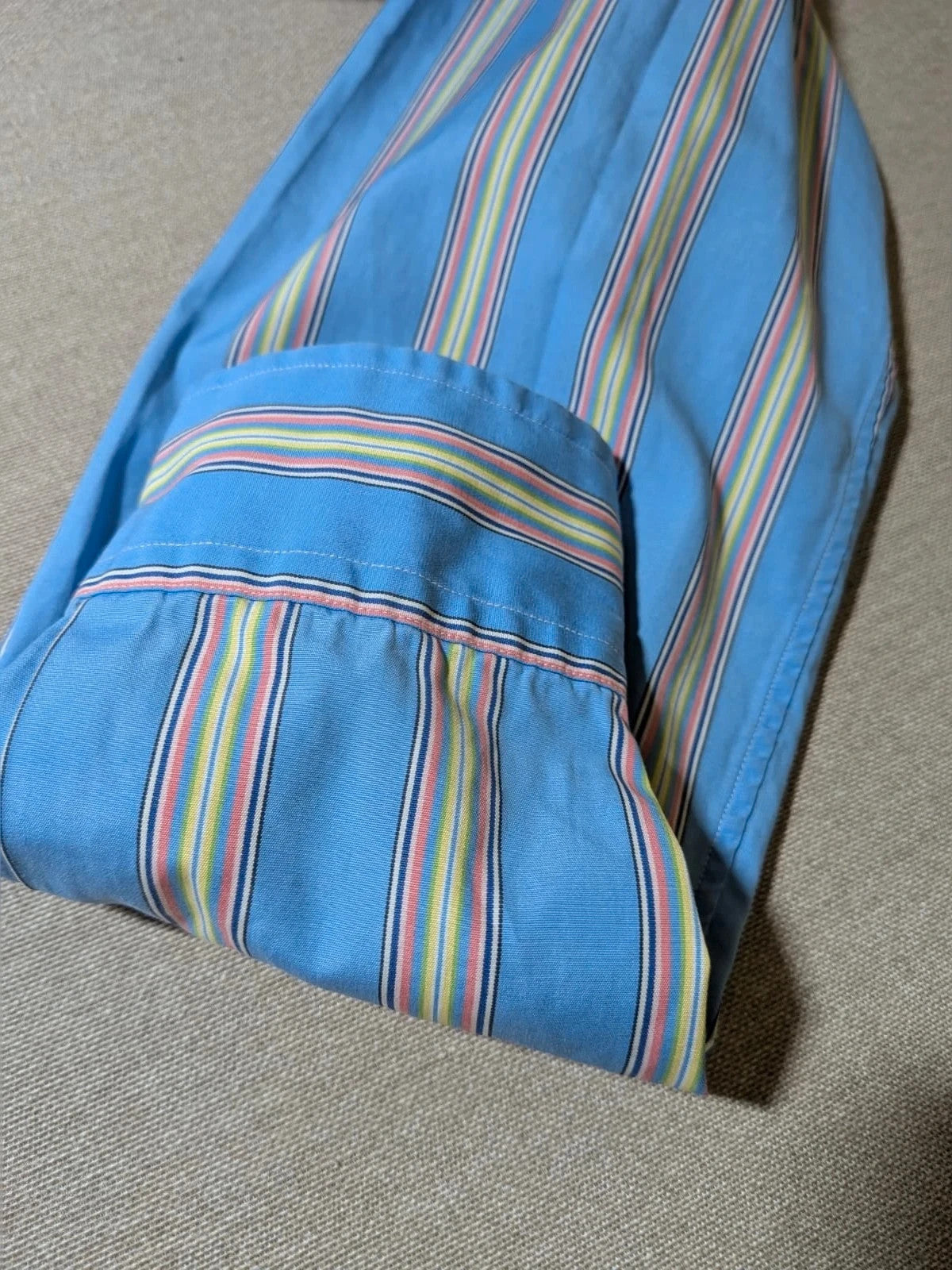 Polo Ralph Lauren multicolor striped shirt with pink pony logo on sky blue background.