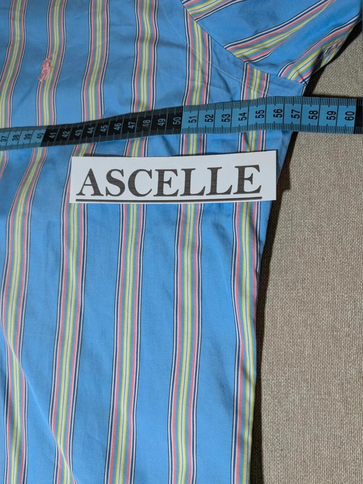 Polo Ralph Lauren multicolor striped shirt with pink pony logo on sky blue background.