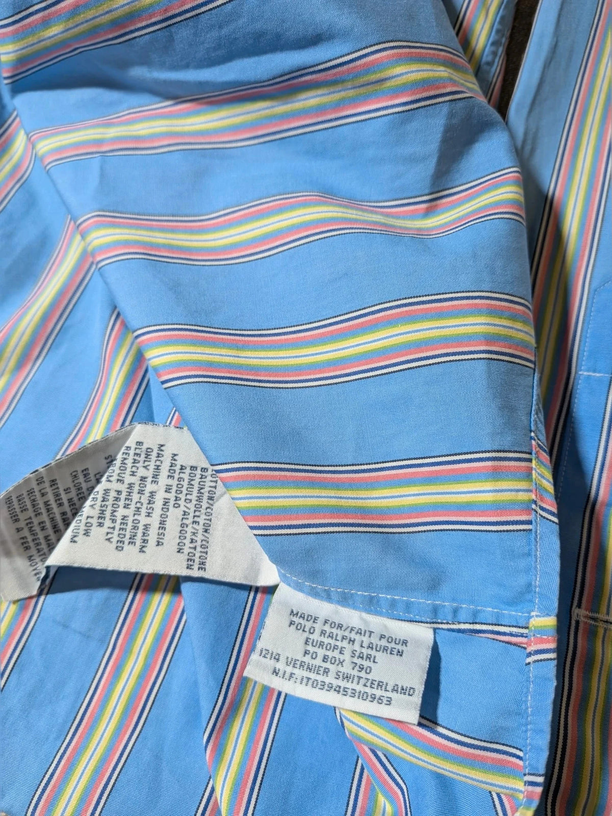 Polo Ralph Lauren multicolor striped shirt with pink pony logo on sky blue background.