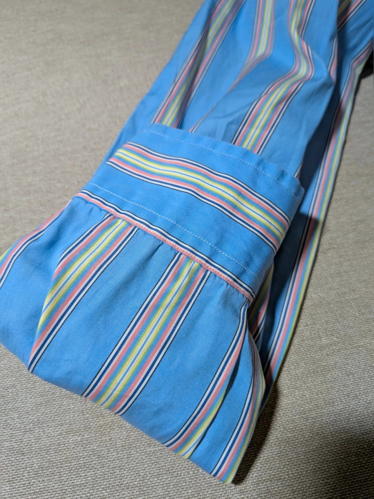 Polo Ralph Lauren multicolor striped shirt with pink pony logo on sky blue background.