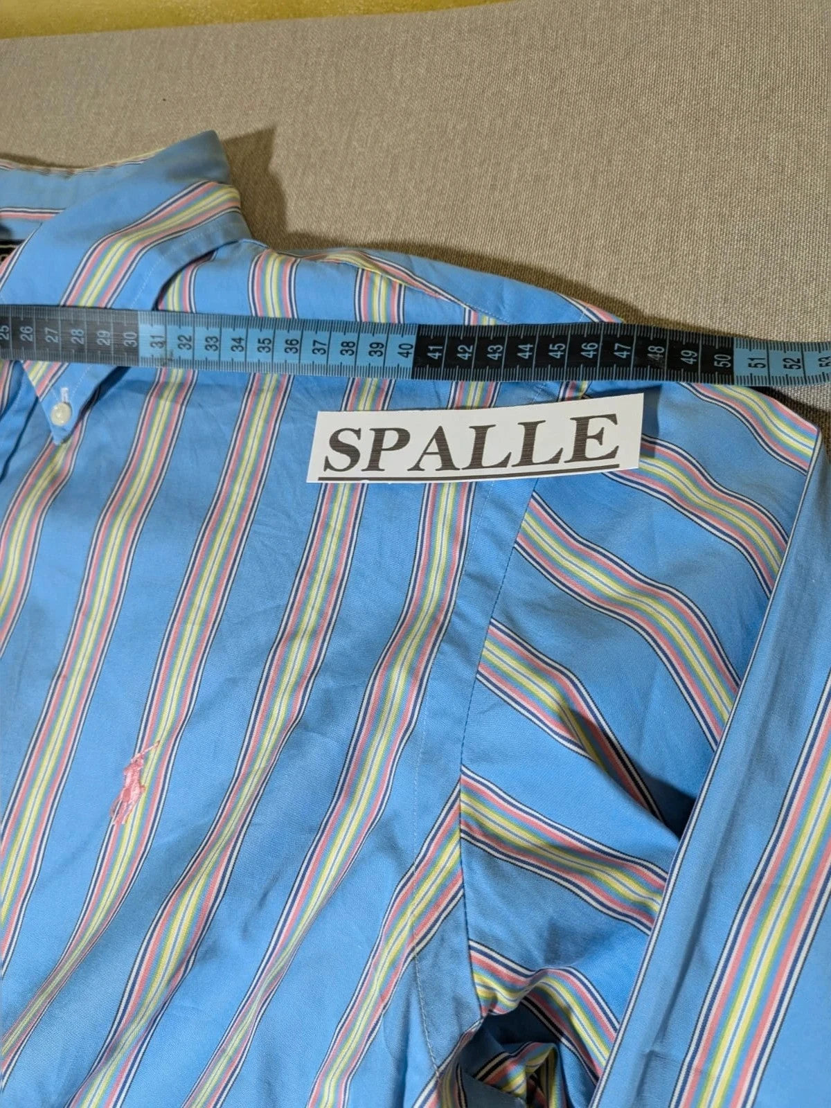Polo Ralph Lauren multicolor striped shirt with pink pony logo on sky blue background.