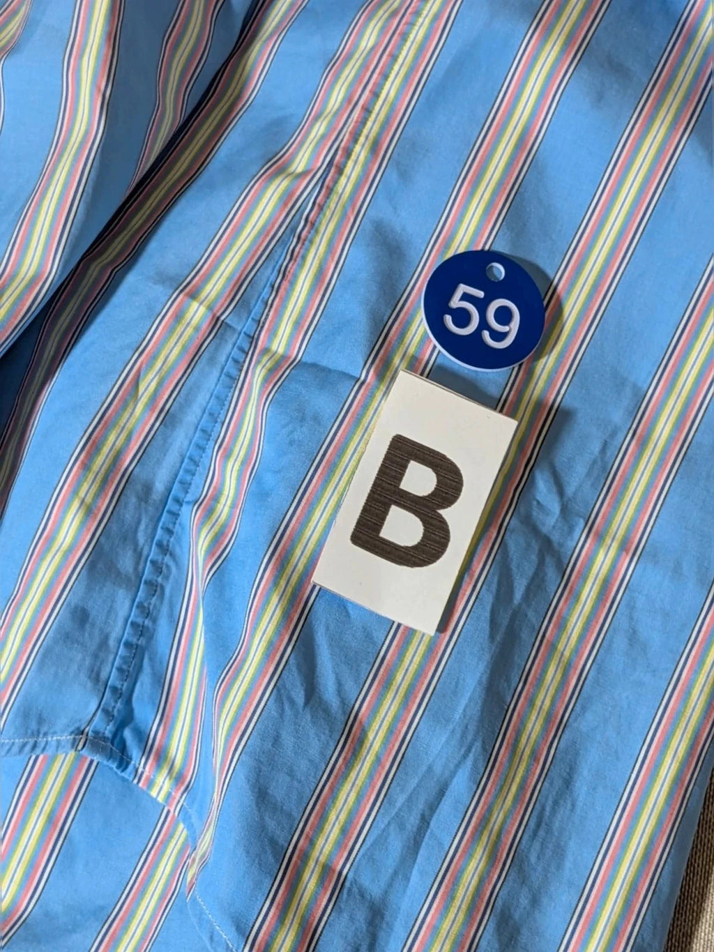Polo Ralph Lauren multicolor striped shirt with pink pony logo on sky blue background.