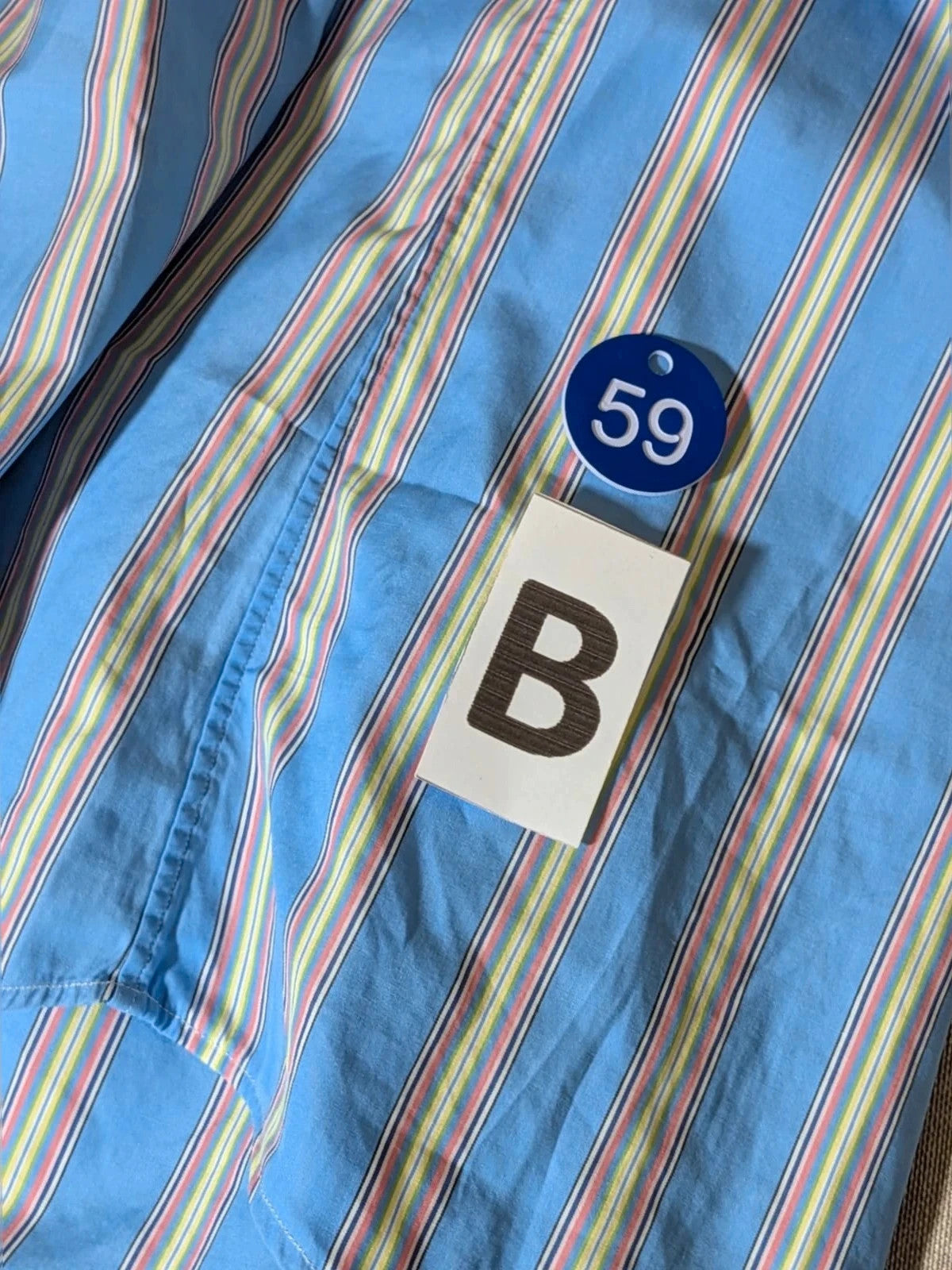 Polo Ralph Lauren multicolor striped shirt with pink pony logo on sky blue background.