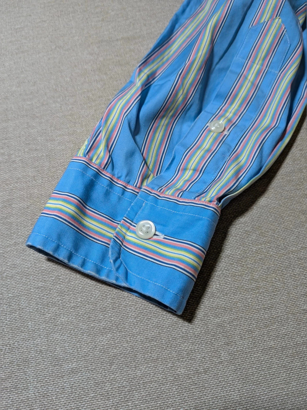 Polo Ralph Lauren multicolor striped shirt with pink pony logo on sky blue background.