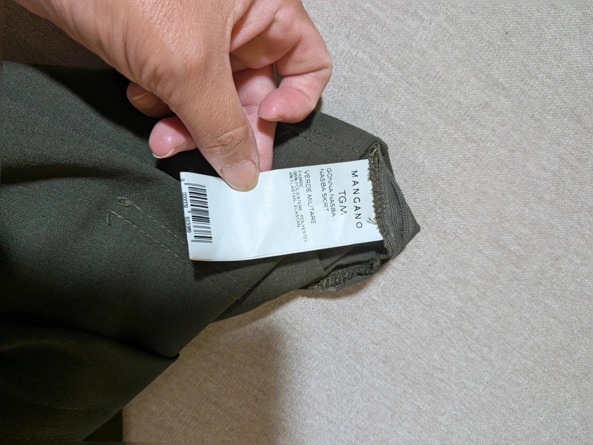 Mangano green military skirt suit with elegant front pleats and metallic ring detail.