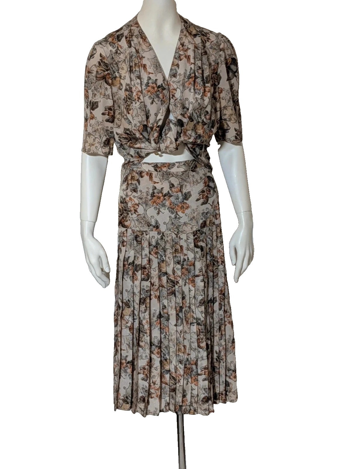 Bellissima beige floral print skirt suit with V-neck blouse and pleated midi skirt.