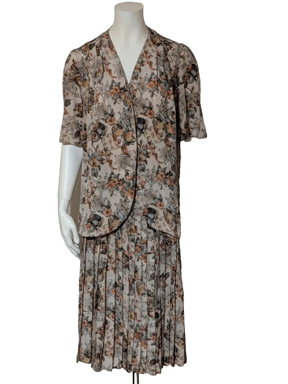 Bellissima beige floral print skirt suit with V-neck blouse and pleated midi skirt.