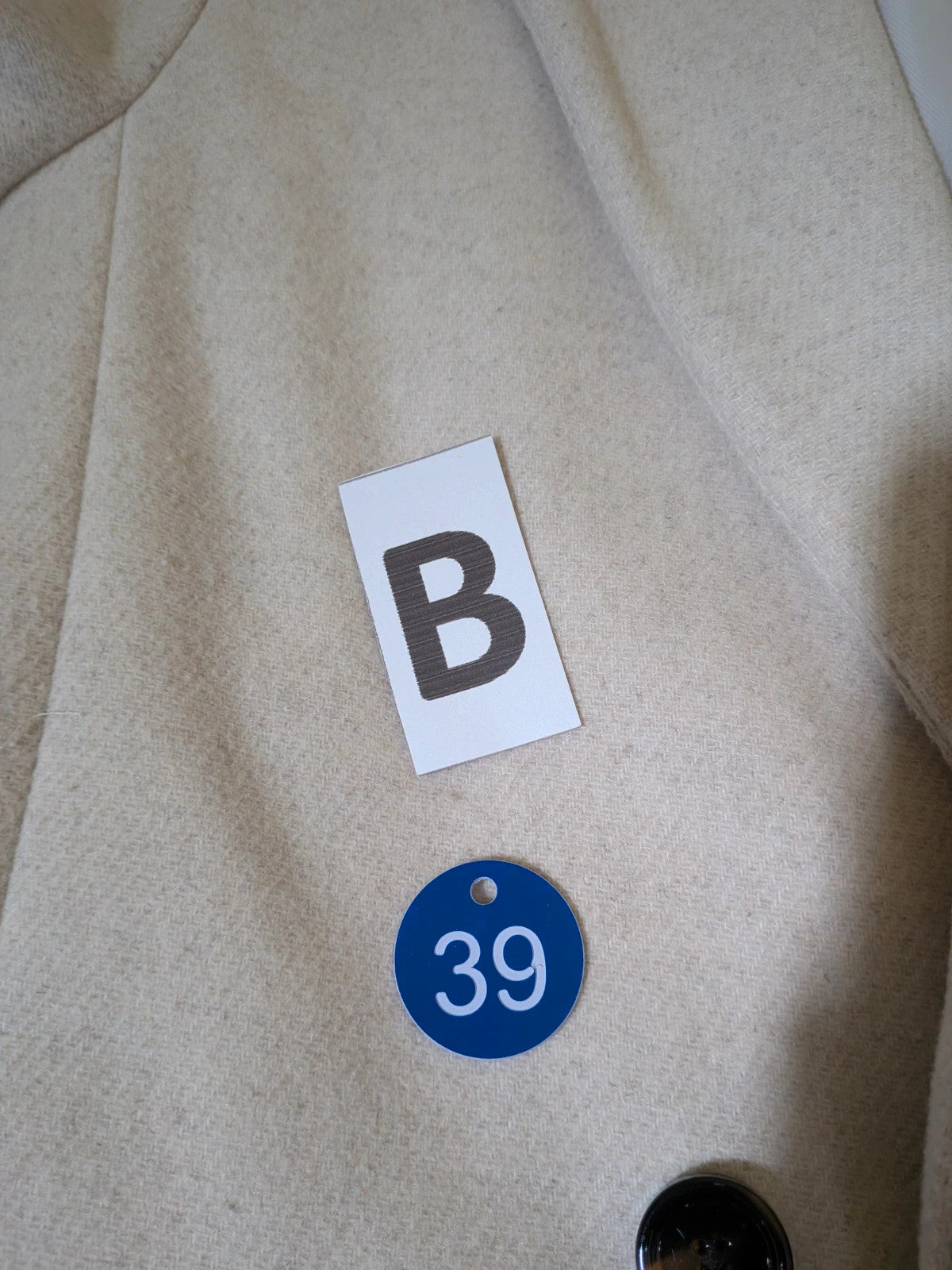 OVS beige double-breasted blazer with dark button closure and classic lapels.