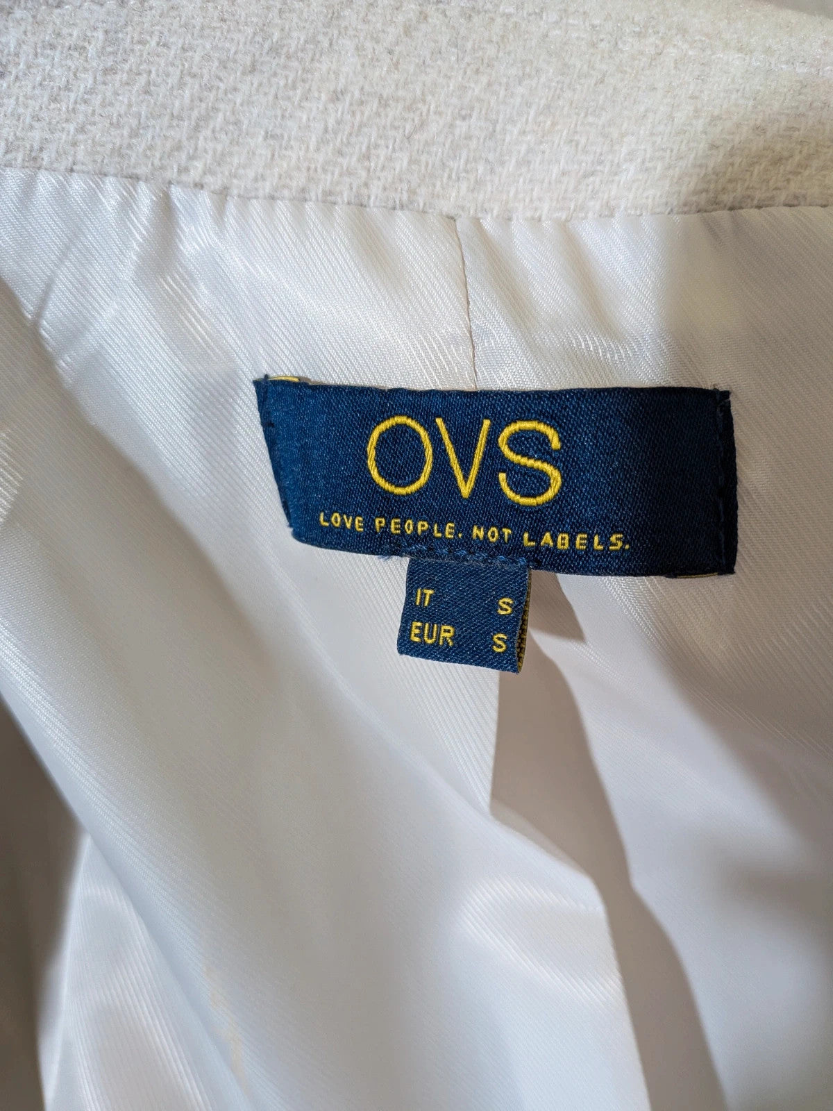 OVS beige double-breasted blazer with dark button closure and classic lapels.
