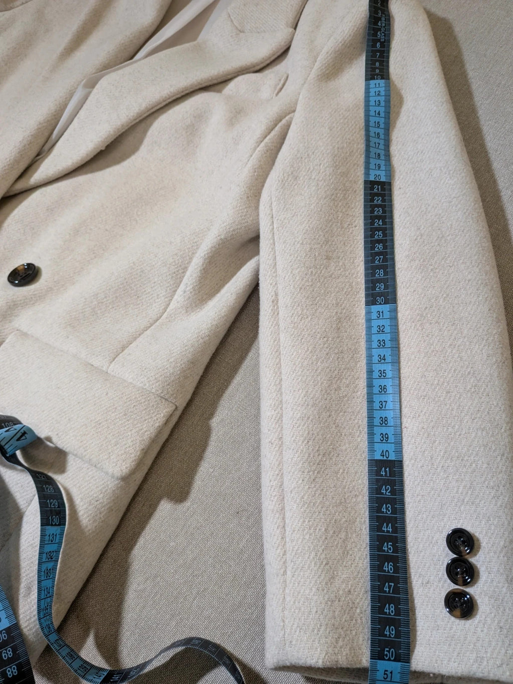 OVS beige double-breasted blazer with dark button closure and classic lapels.