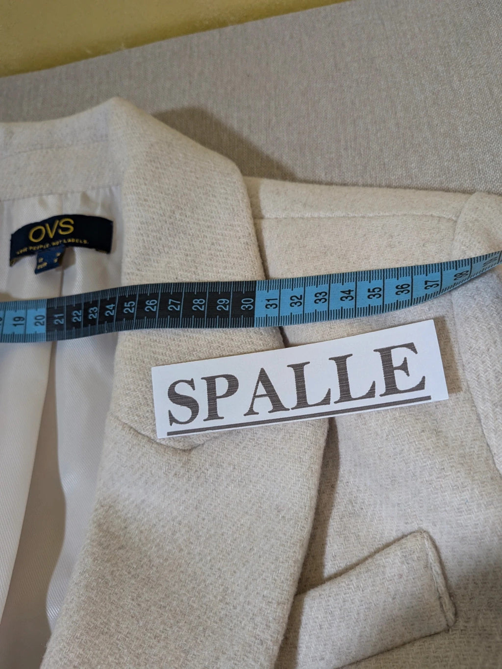 OVS beige double-breasted blazer with dark button closure and classic lapels.