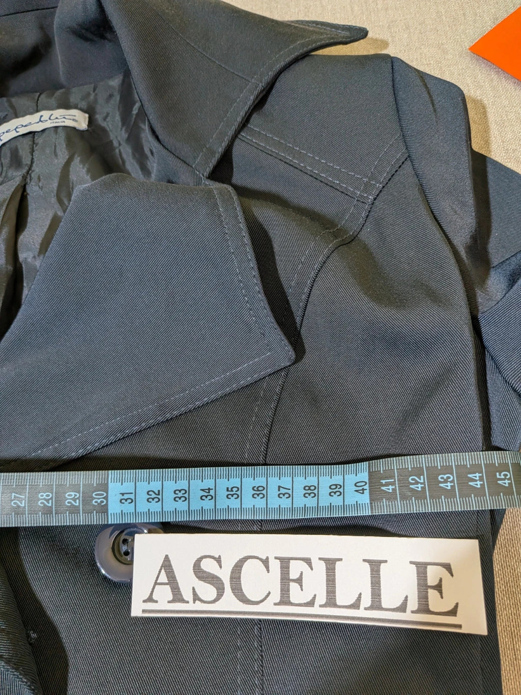 Pepe navy trench coat with double-breasted buttons, belted waist, and structured shoulders.