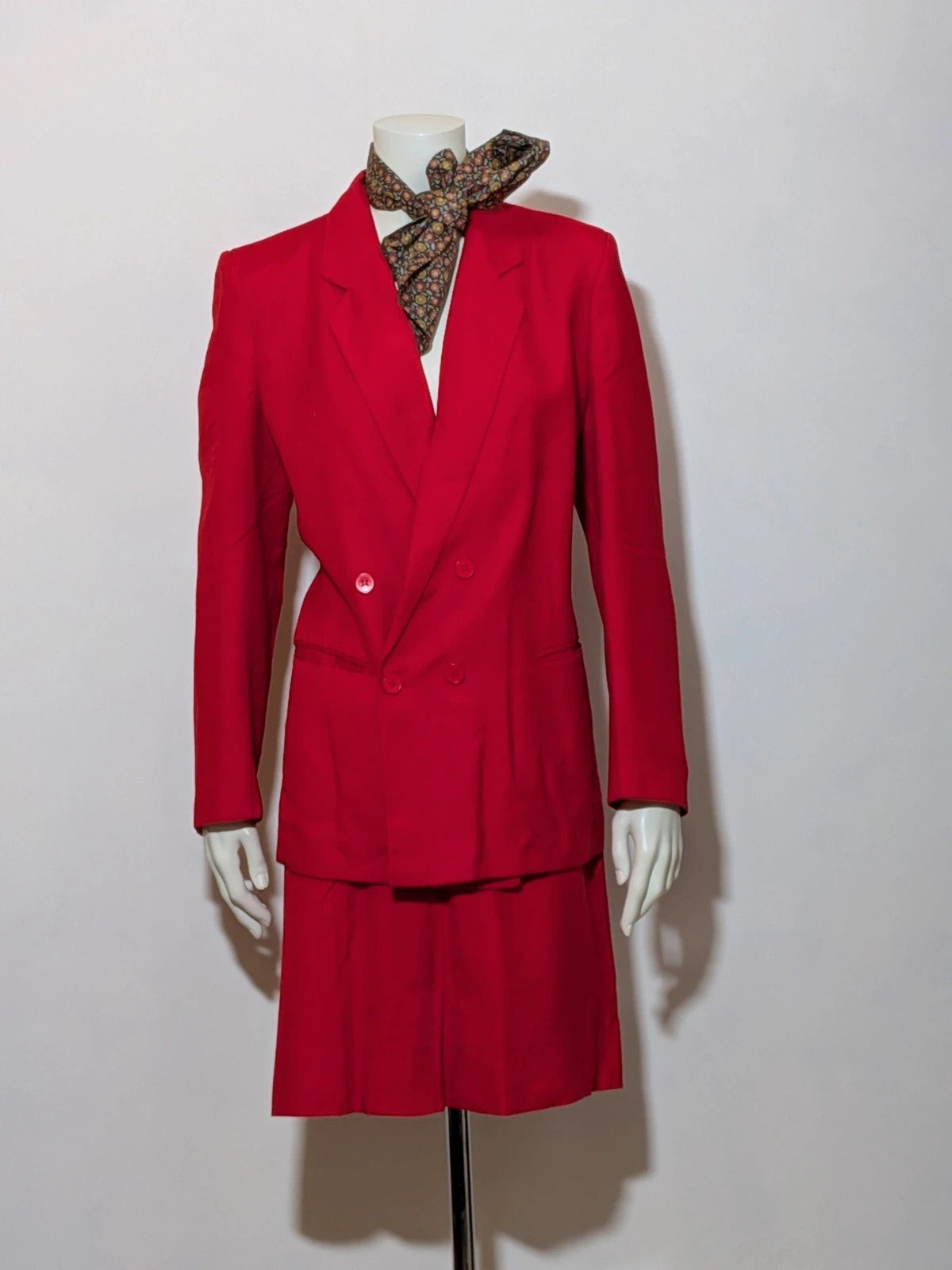 Tessuto red skirt suit with double-breasted jacket and linen-like texture.