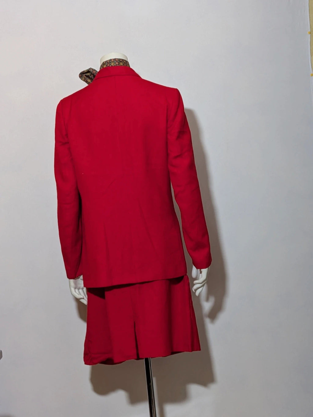 Tessuto red skirt suit with double-breasted jacket and linen-like texture.