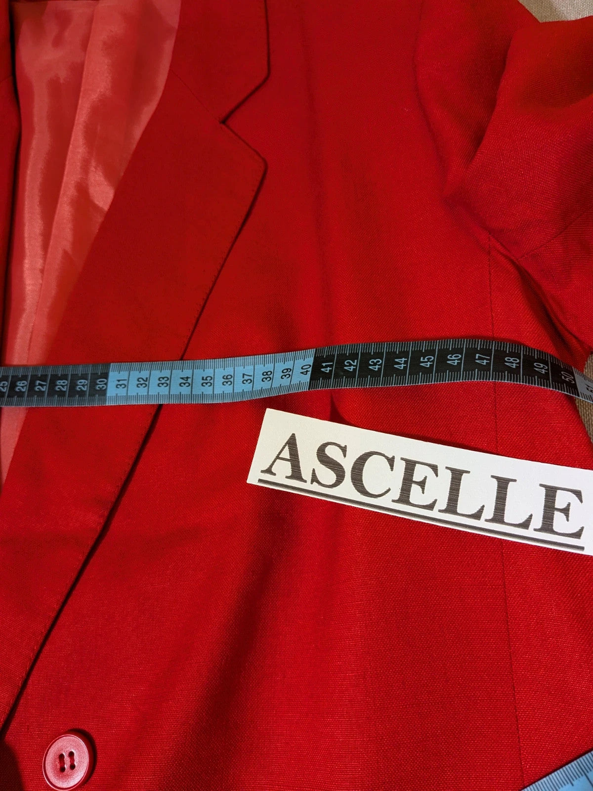 Tessuto red skirt suit with double-breasted jacket and linen-like texture.