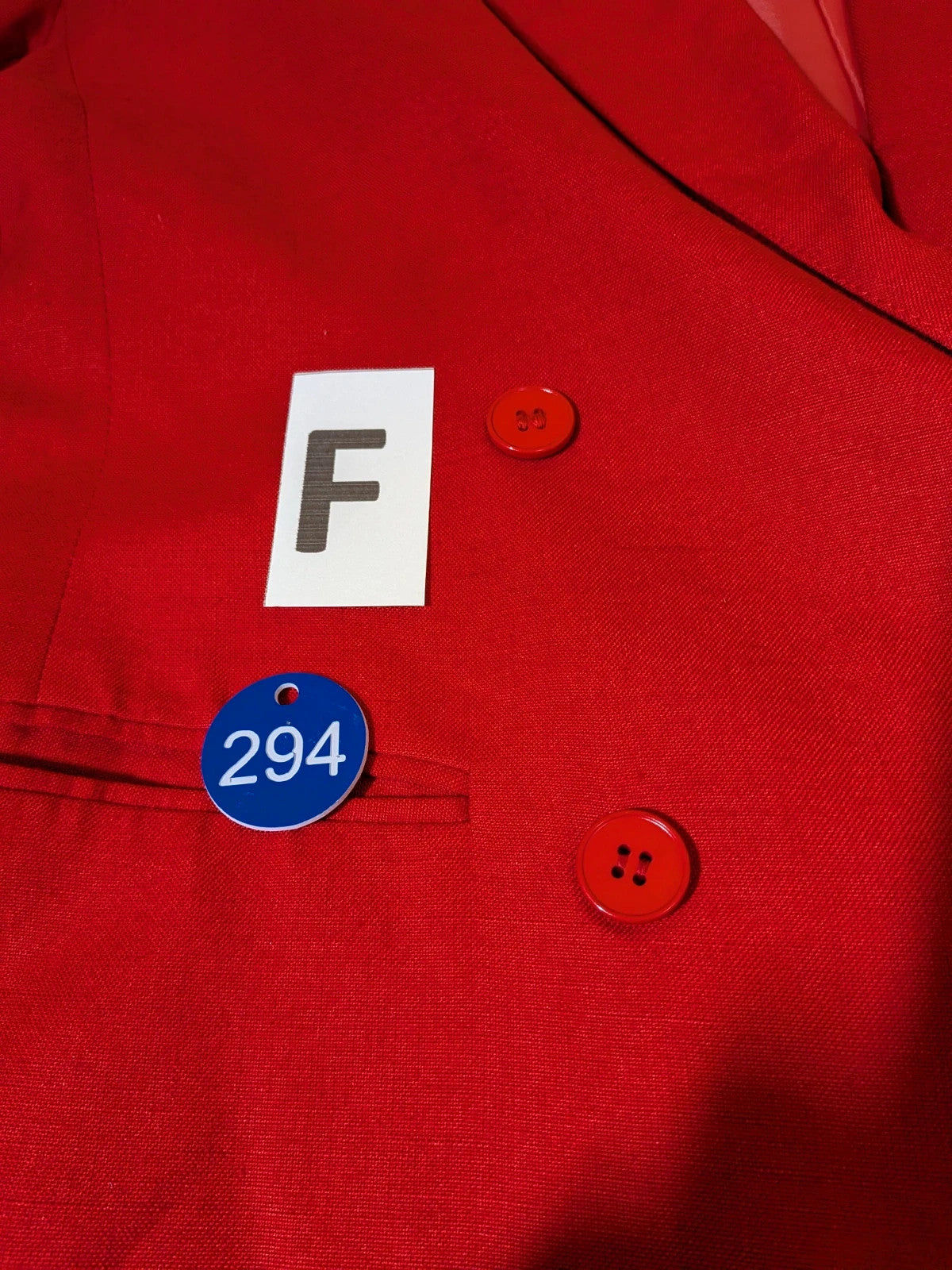 Tessuto red skirt suit with double-breasted jacket and linen-like texture.