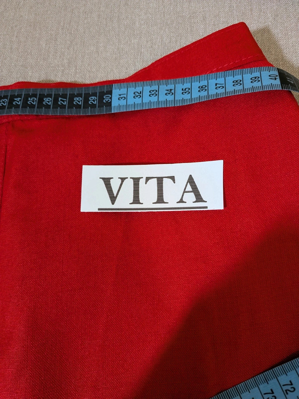 Tessuto red skirt suit with double-breasted jacket and linen-like texture.