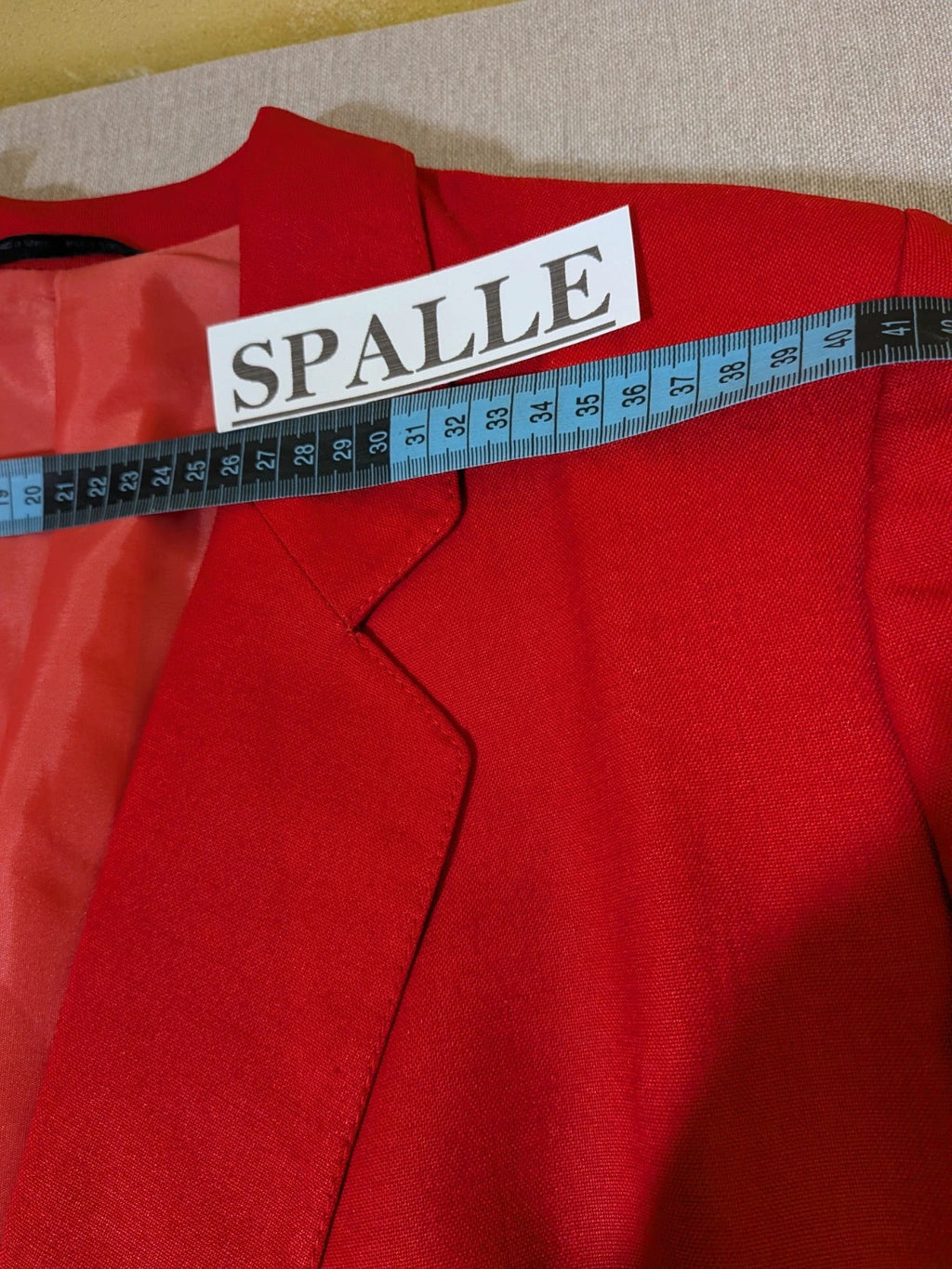 Tessuto red skirt suit with double-breasted jacket and linen-like texture.