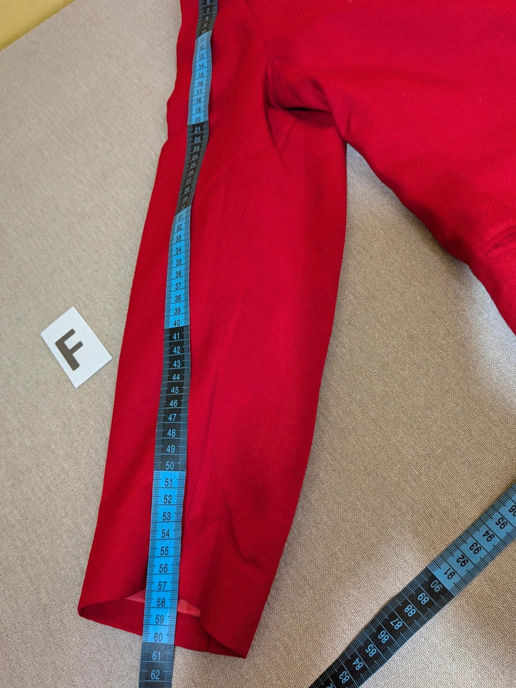 Tessuto red skirt suit with double-breasted jacket and linen-like texture.