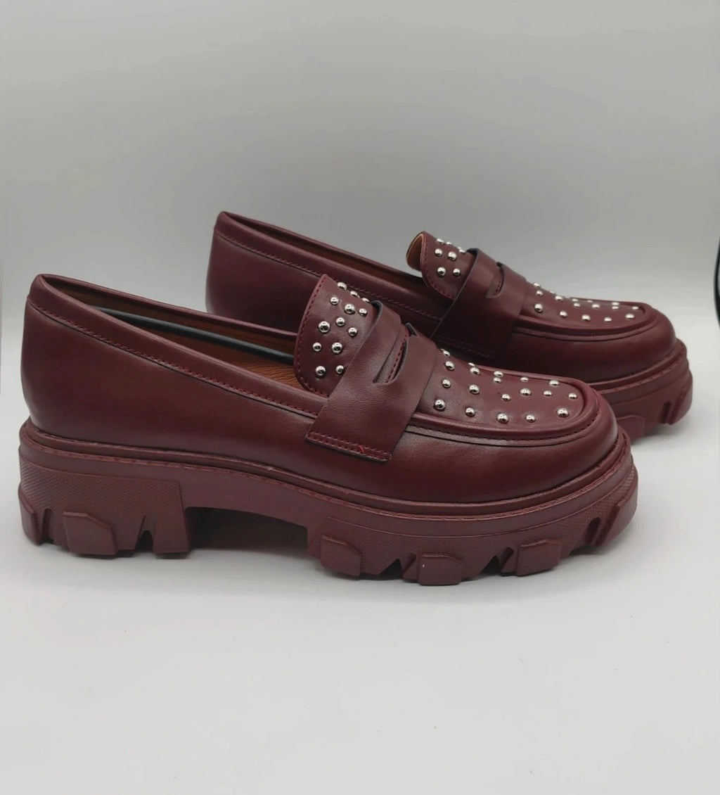 Mocassino burgundy shoes with high sole and sleek design.