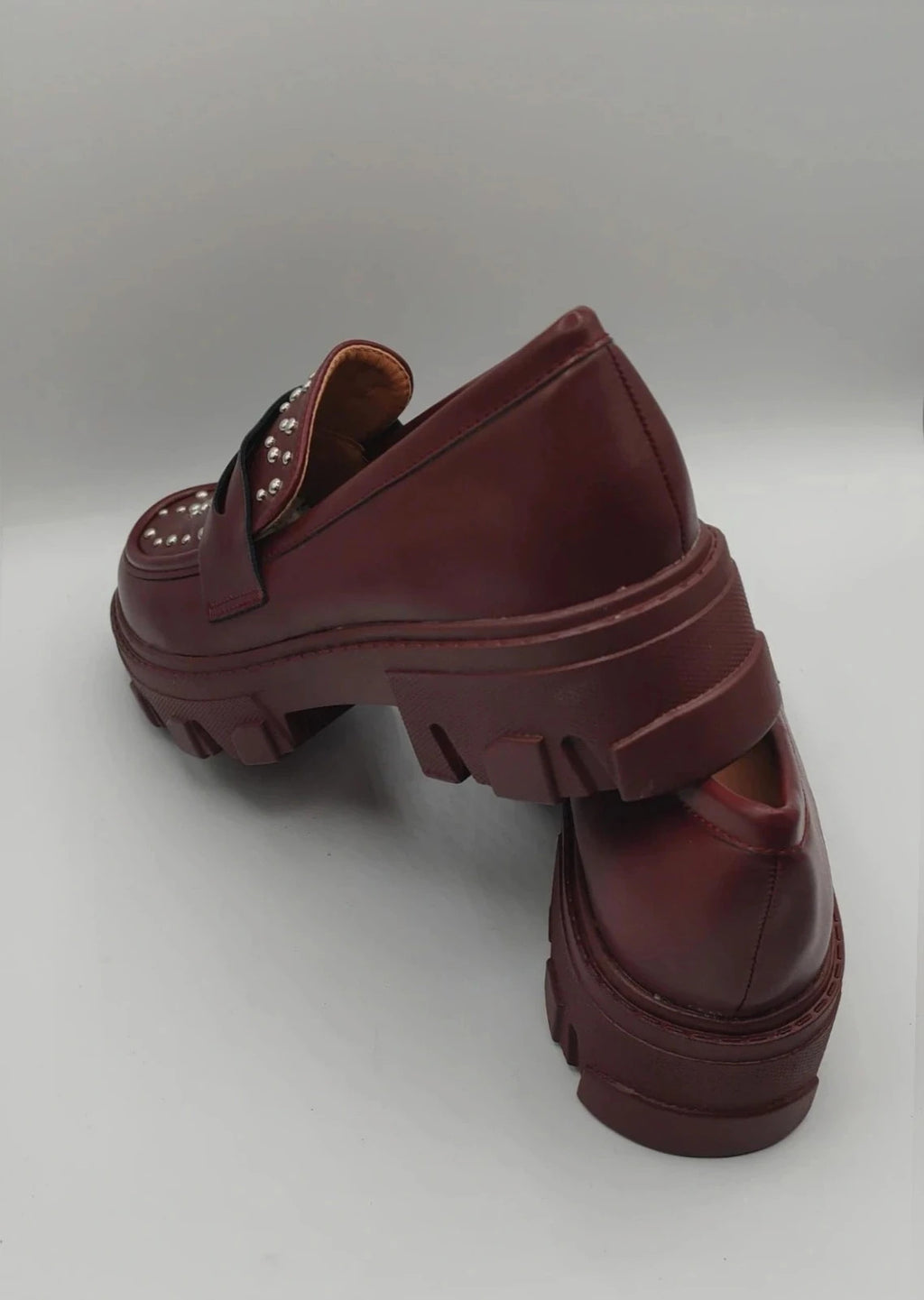 Mocassino burgundy shoes with high sole and sleek design.