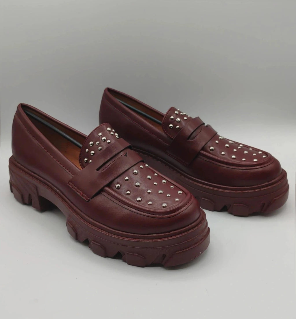 Mocassino burgundy shoes with high sole and sleek design.