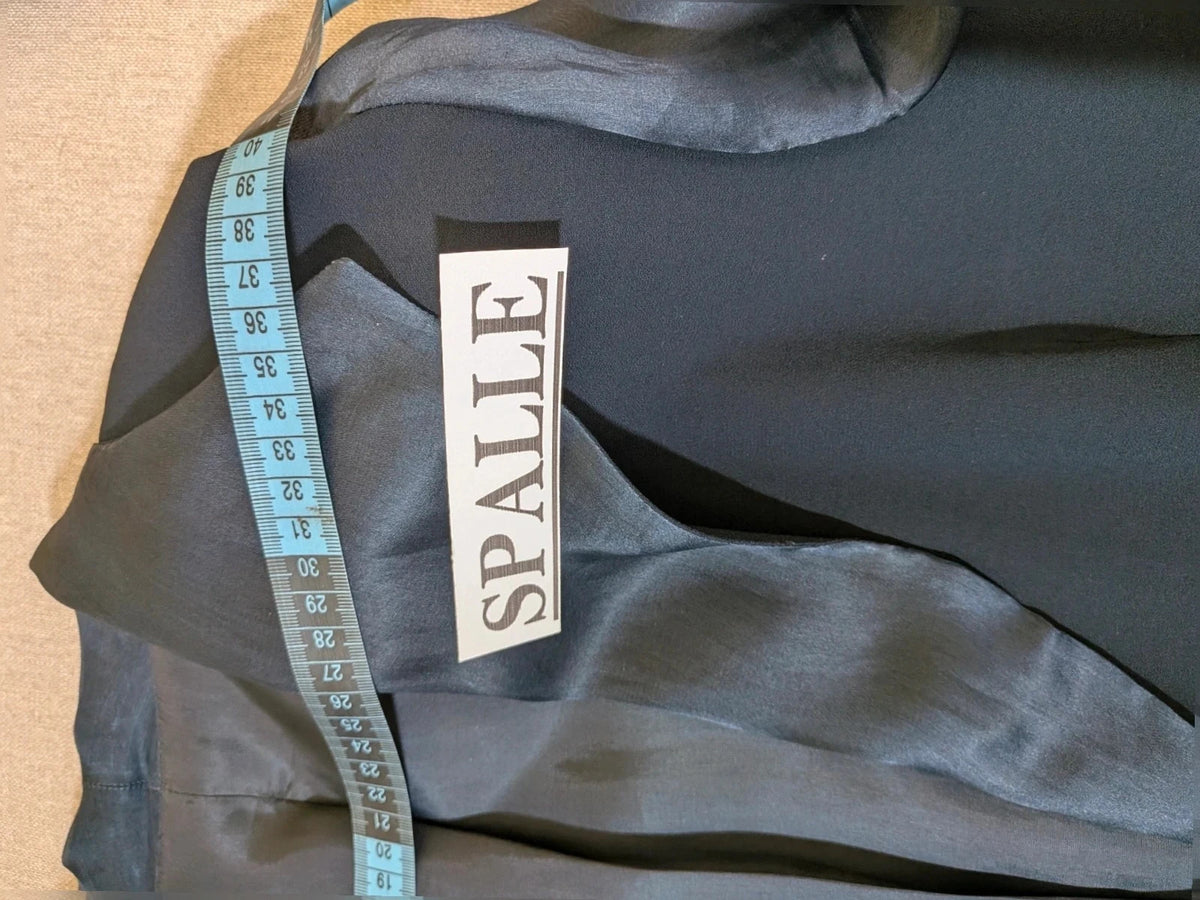 Blazer black skirt suit with navy satin lapels and sheer chiffon sleeves, jeweled clasp detail.