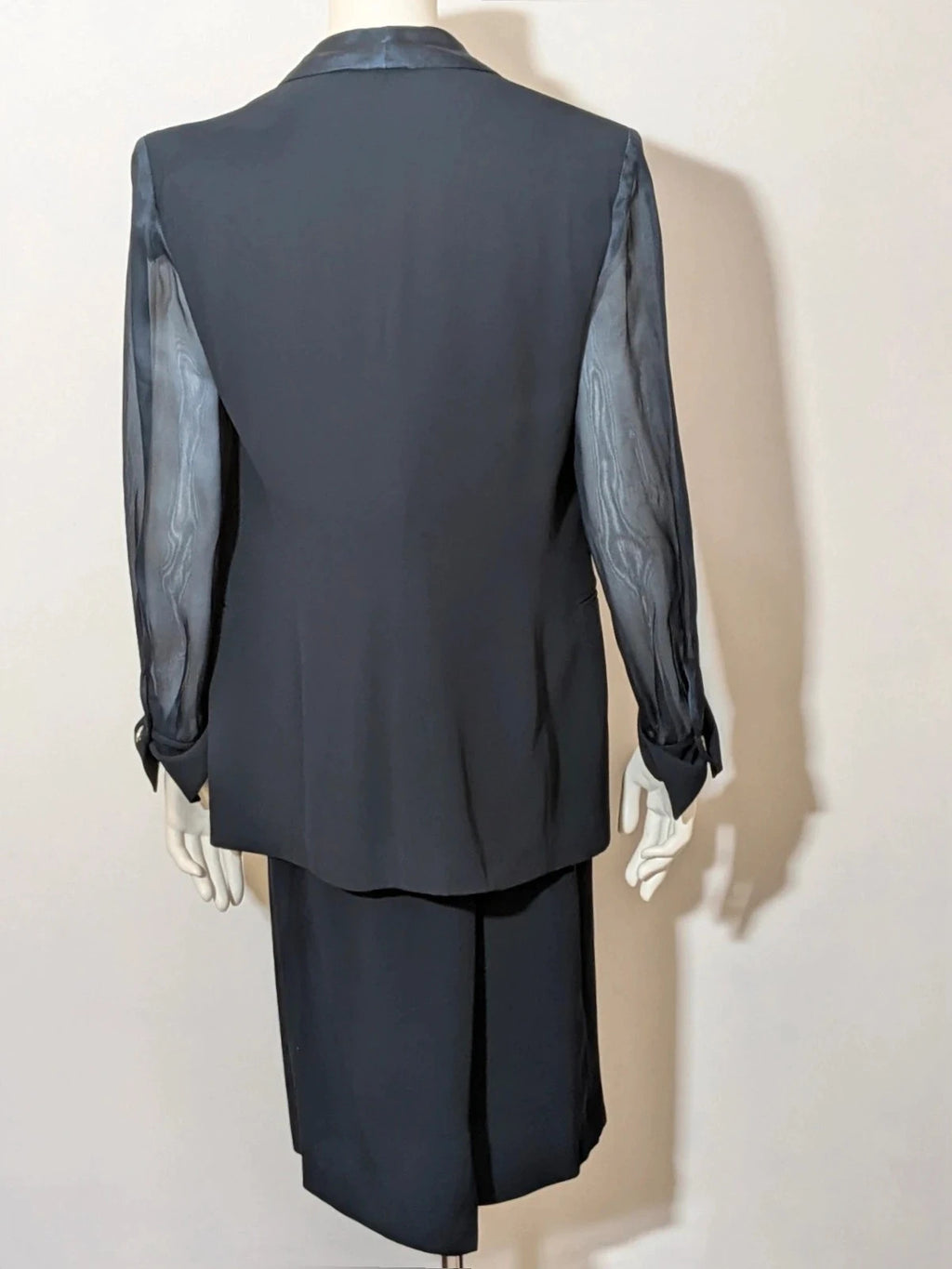 Blazer black skirt suit with navy satin lapels and sheer chiffon sleeves, jeweled clasp detail.