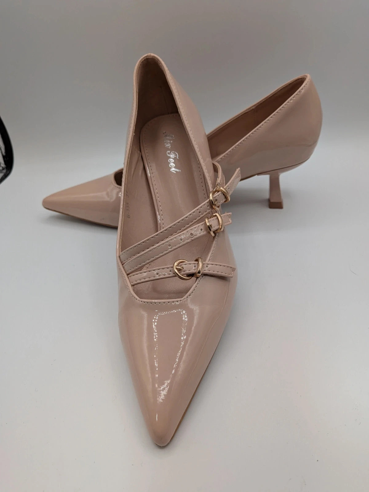 Mix Feel beige heels with pointed toe, glossy patent finish, and decorative gold buckles.