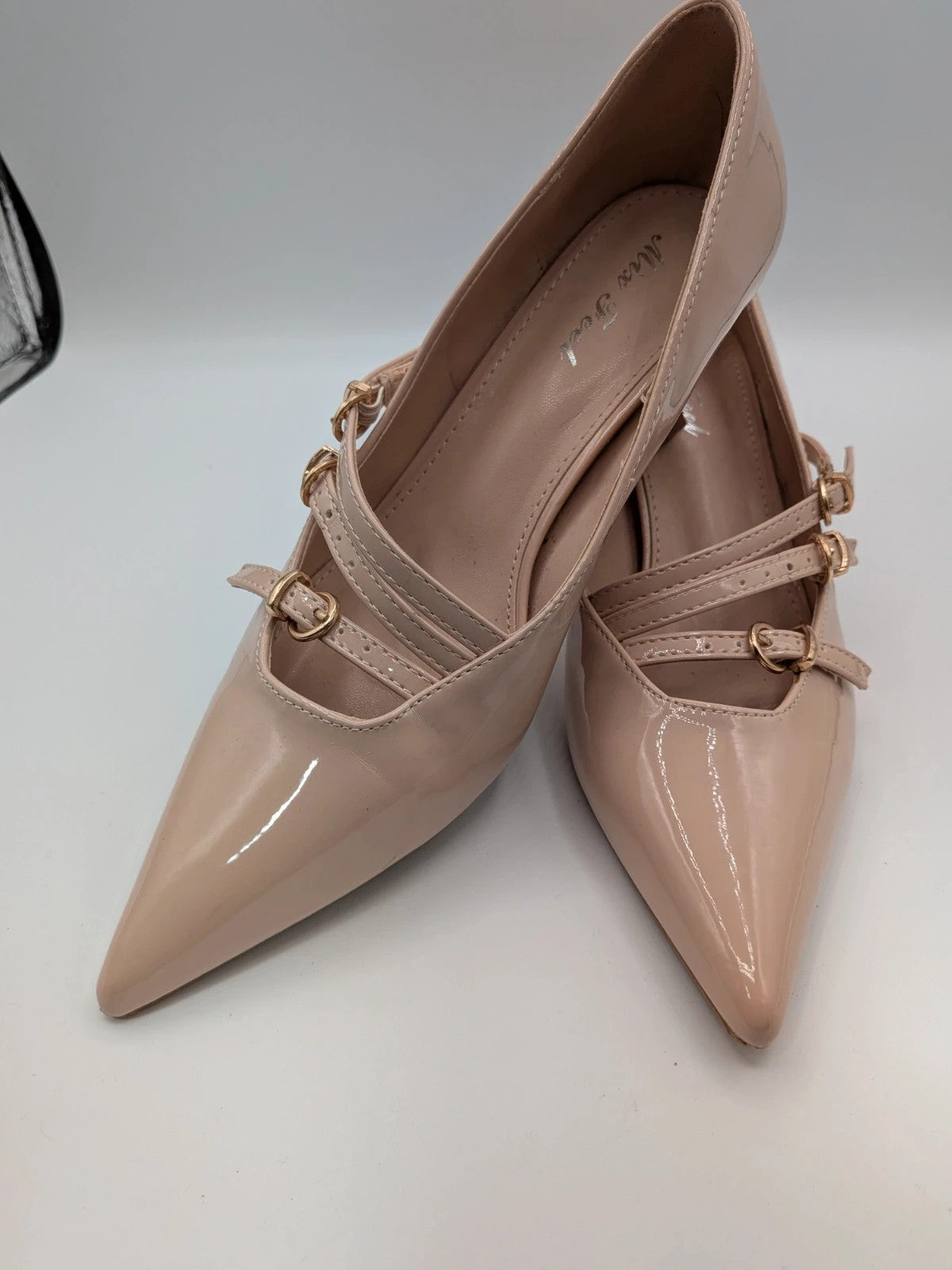 Mix Feel beige heels with pointed toe, glossy patent finish, and decorative gold buckles.