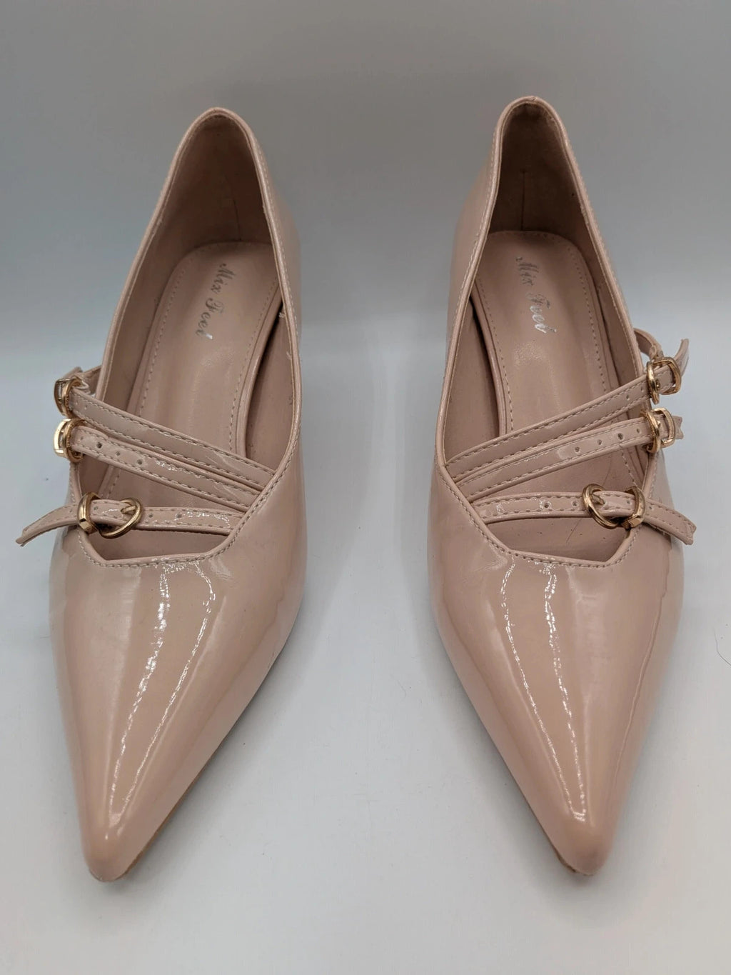 Mix Feel beige heels with pointed toe, glossy patent finish, and decorative gold buckles.