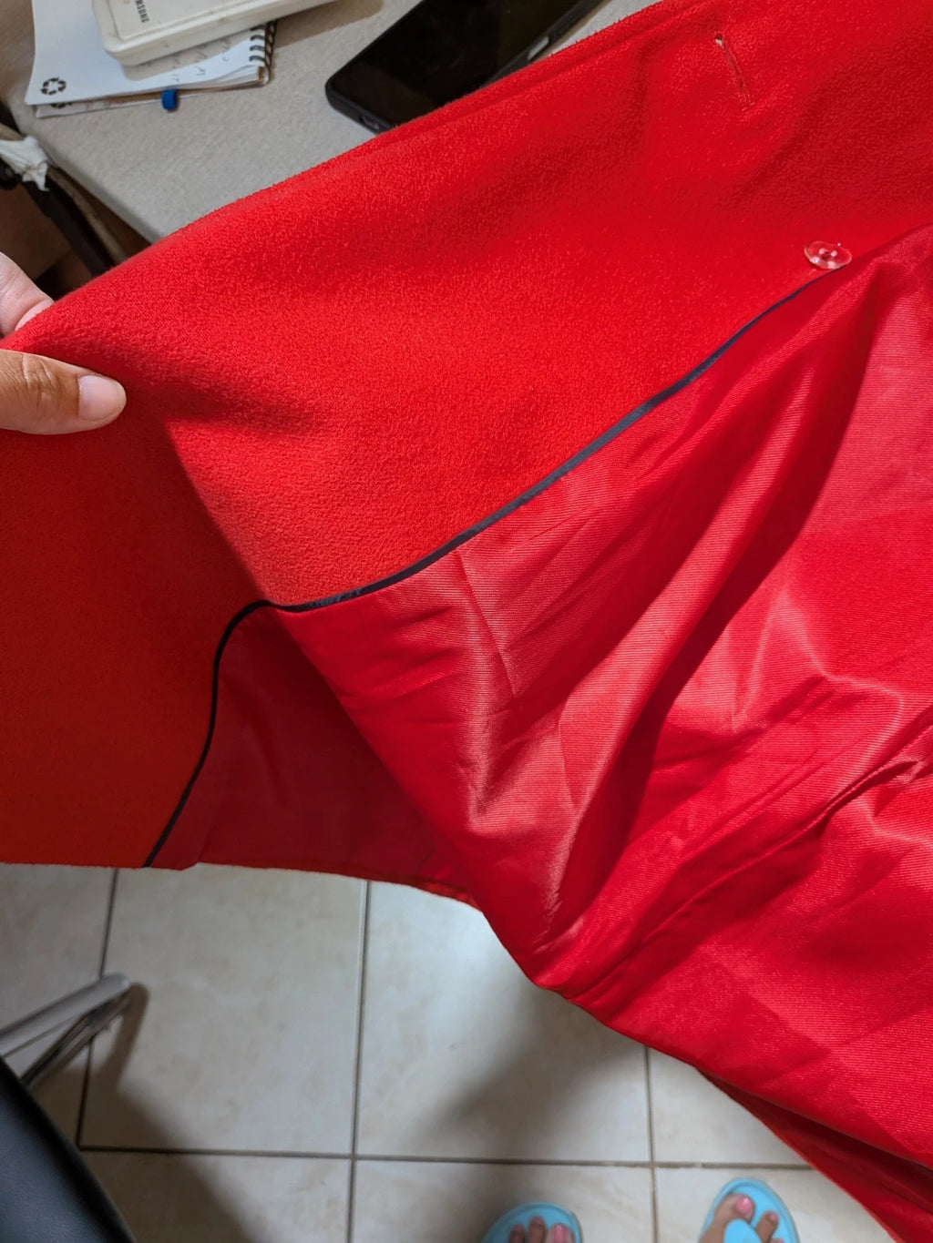 Studio F red coat with black button closure and gold logo tag on collar.