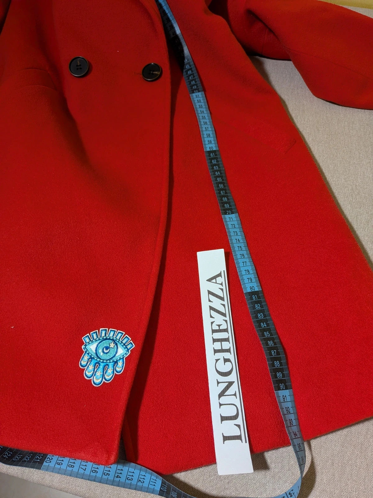 Studio F red coat with black button closure and gold logo tag on collar.