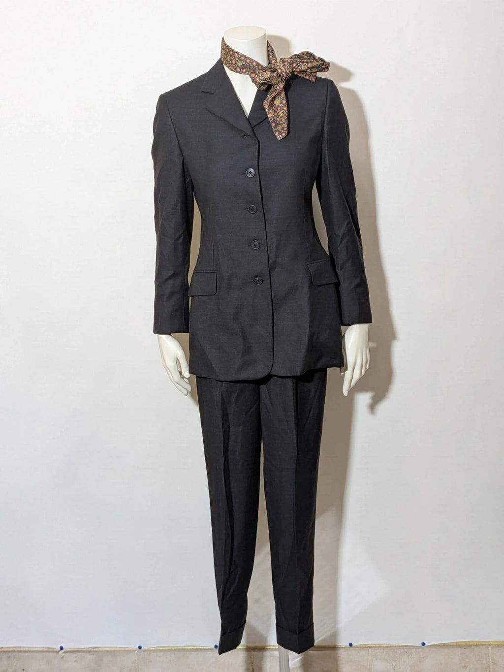 Synthesis Femme grey suit with structured jacket, four-button closure, and tailored trousers.