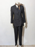 Synthesis Femme grey suit with structured jacket, four-button closure, and tailored trousers.