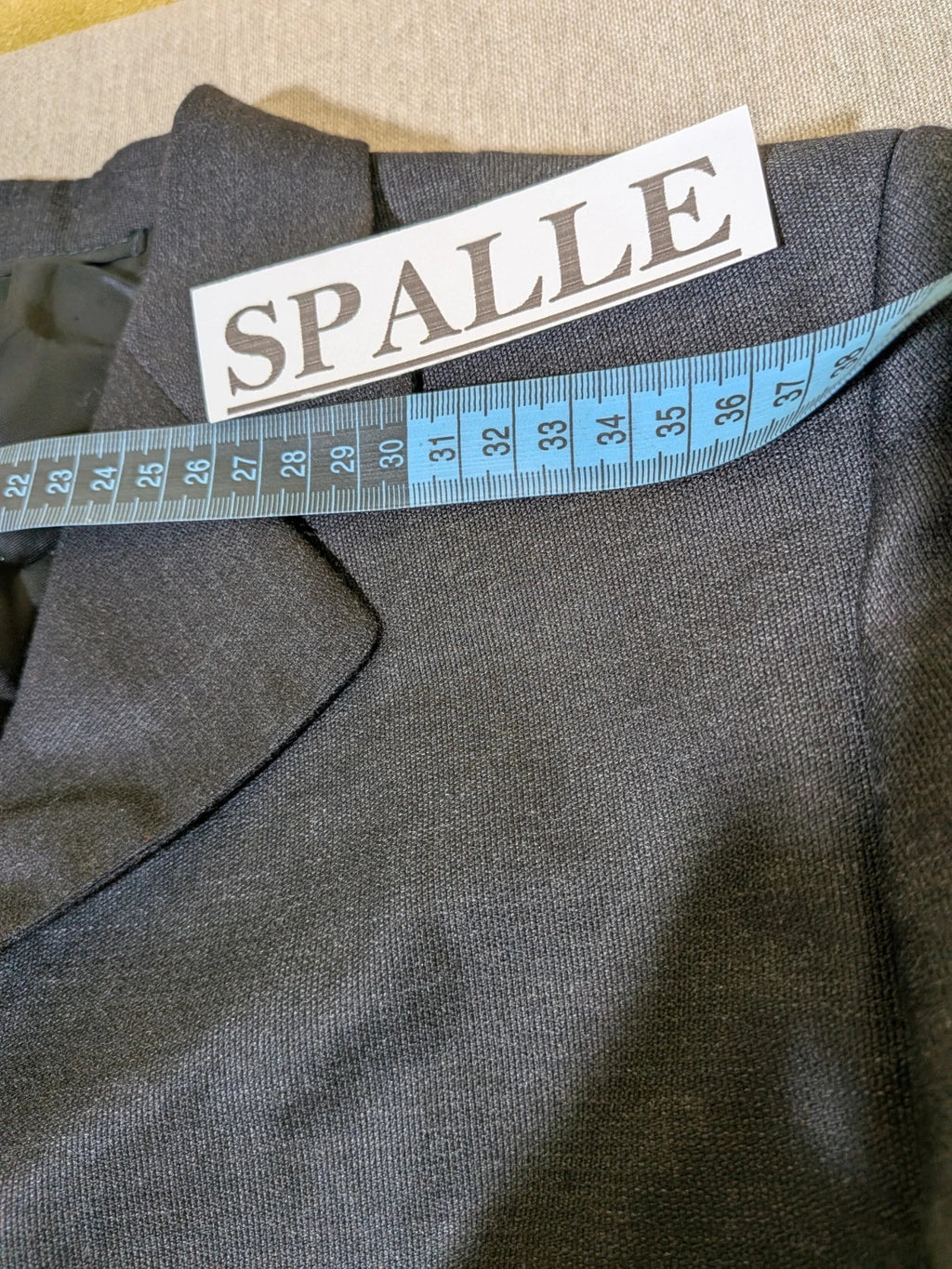 Synthesis Femme grey suit with structured jacket, four-button closure, and tailored trousers.
