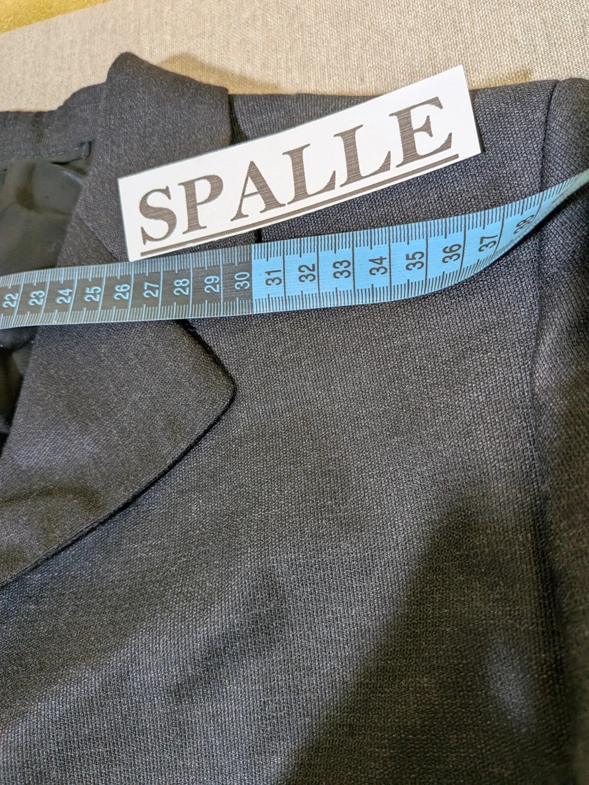 Synthesis Femme grey suit with structured jacket, four-button closure, and tailored trousers.