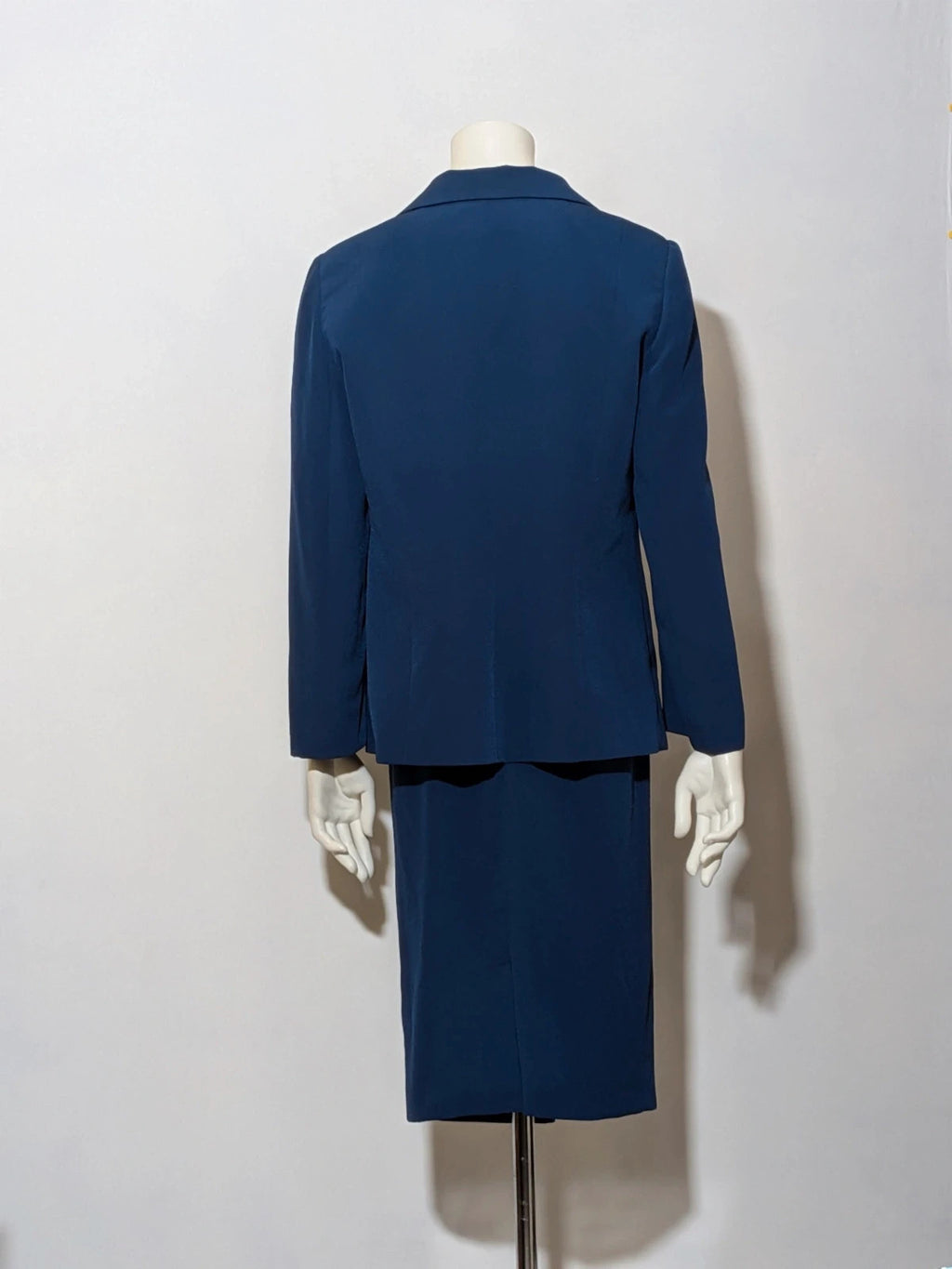 Romy blue skirt suit with classic blazer, two-button closure, and pencil skirt.
