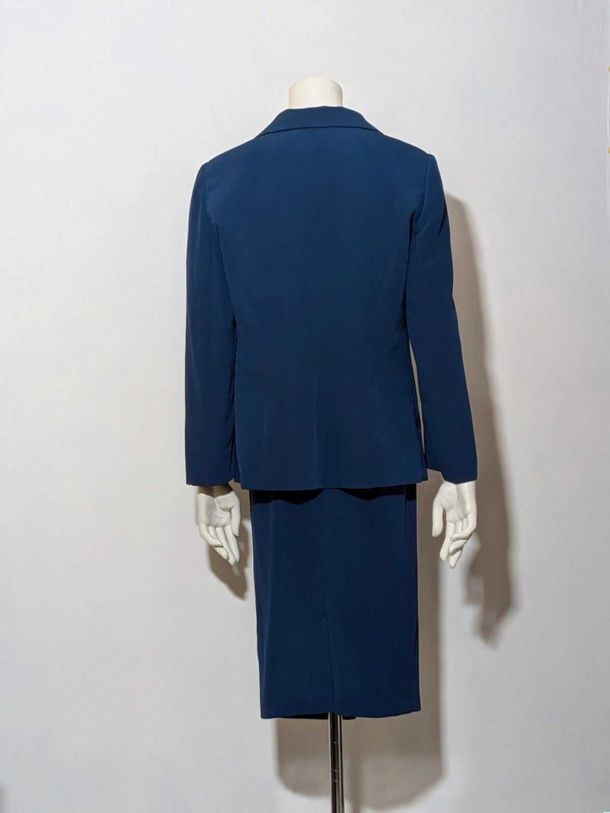 Romy blue skirt suit with classic blazer, two-button closure, and pencil skirt.
