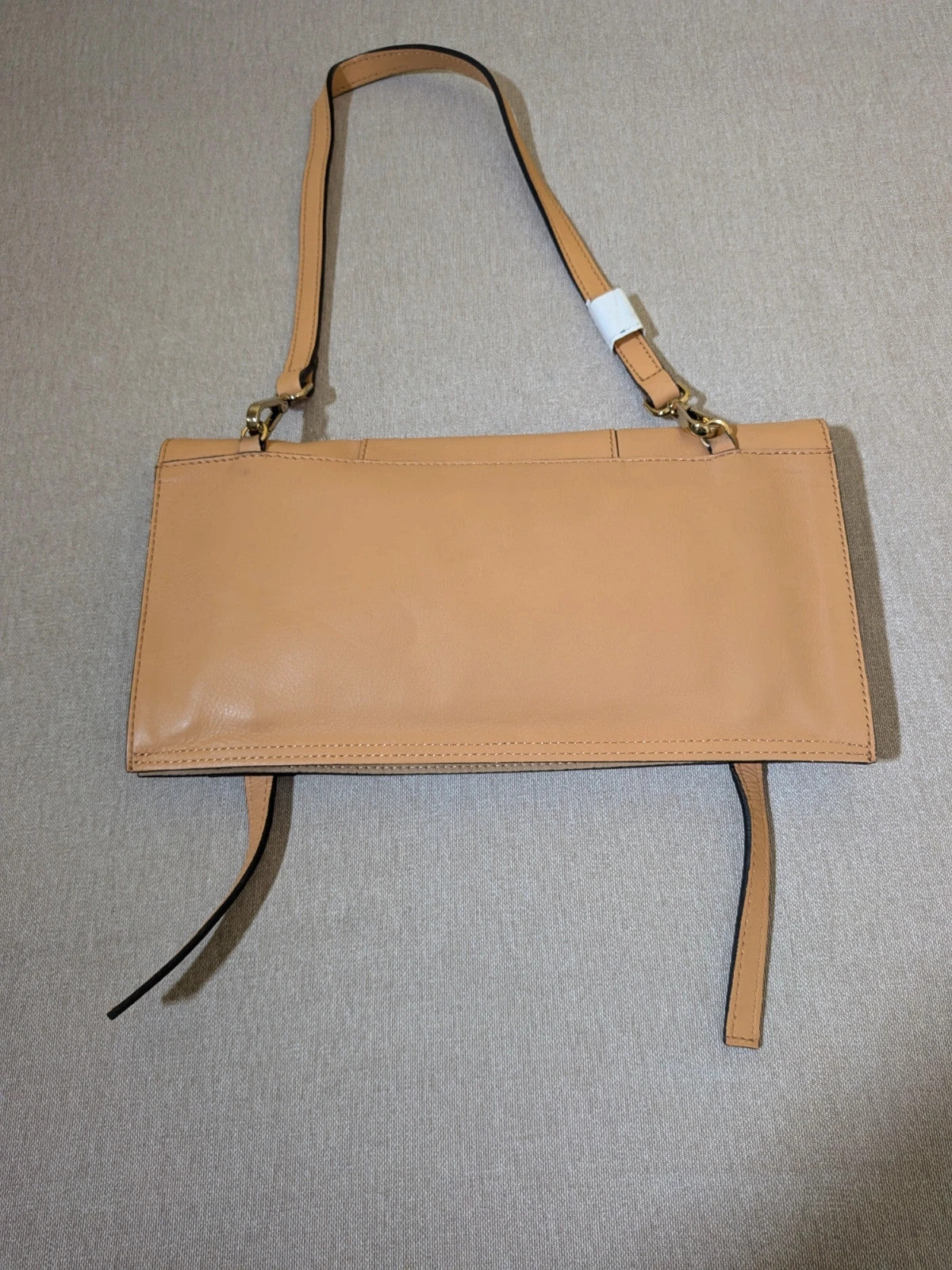 Innuè beige genuine leather shoulder bag with gold hardware and decorative buckles.
