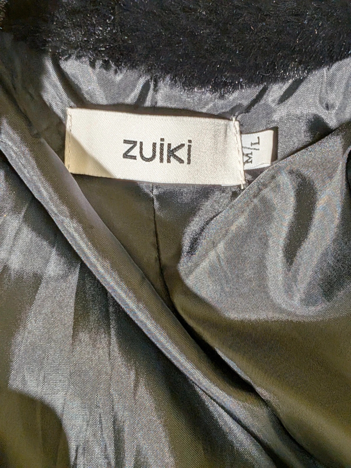 Zuiki black teddy coat with wide lapel, side pockets, and soft faux fur material.