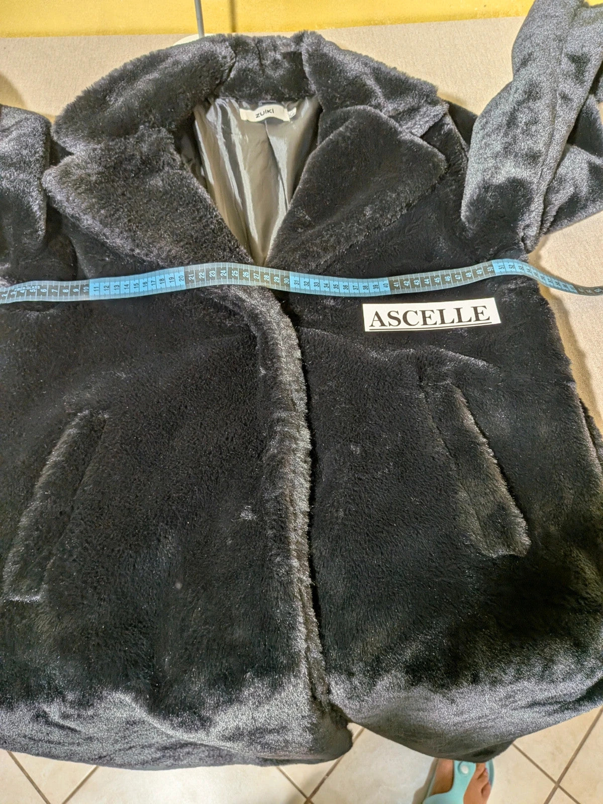 Zuiki black teddy coat with wide lapel, side pockets, and soft faux fur material.