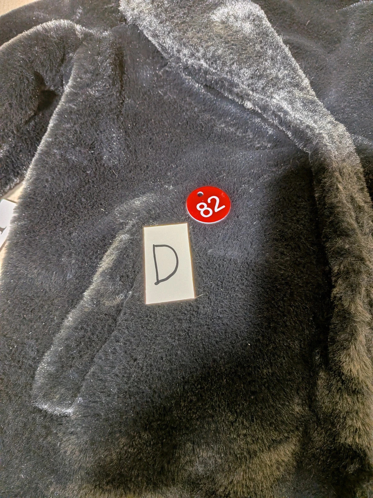 Zuiki black teddy coat with wide lapel, side pockets, and soft faux fur material.
