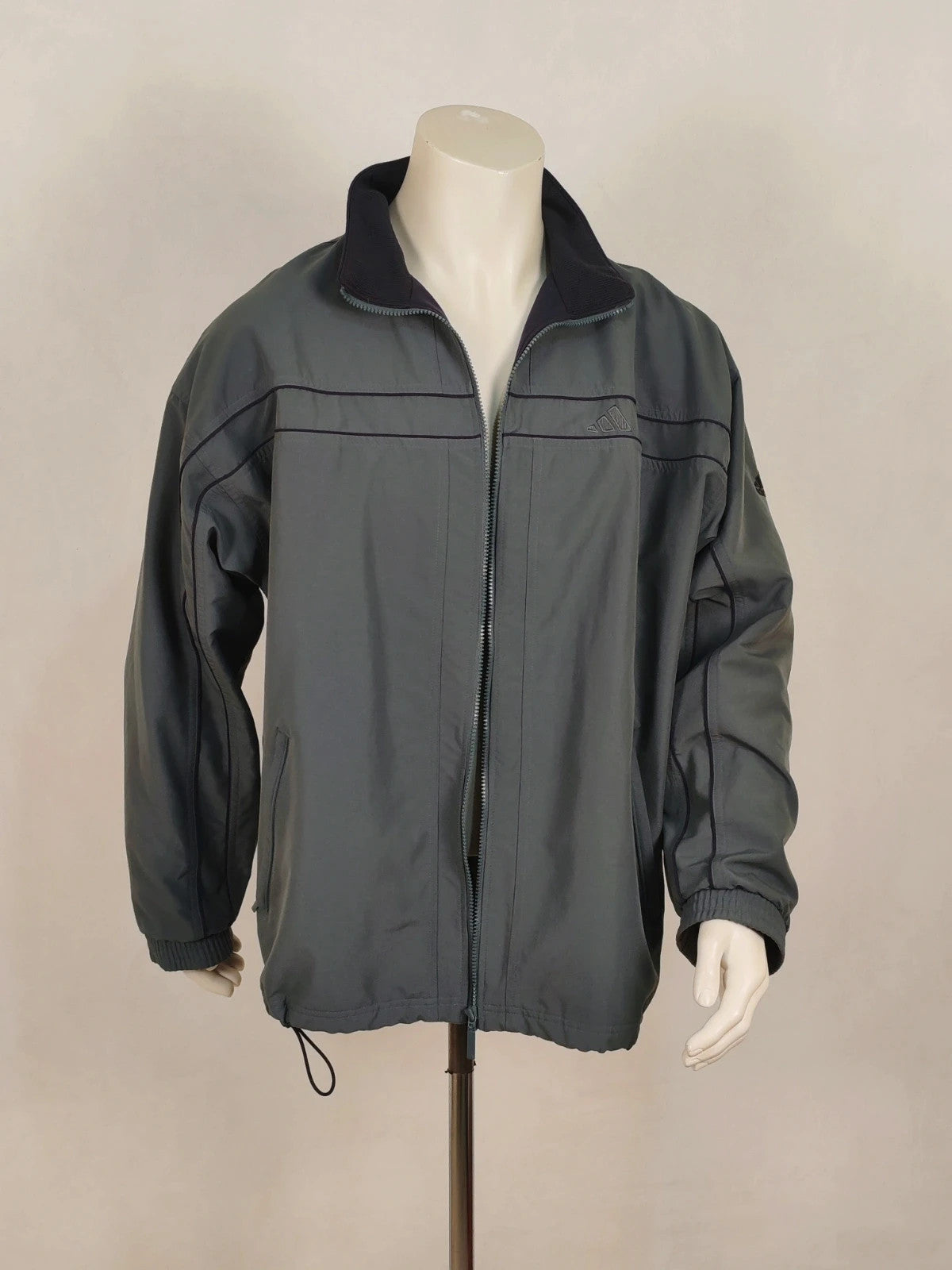 Adidas grey track jacket, high collar, zip closure, tonal details, vintage 90s style.